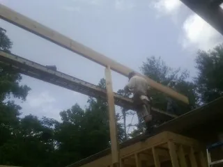 Carpenter setting a ridge beam over a new addition frame — Ice Dam Removal by Roofing Brothers in Old Saybrook