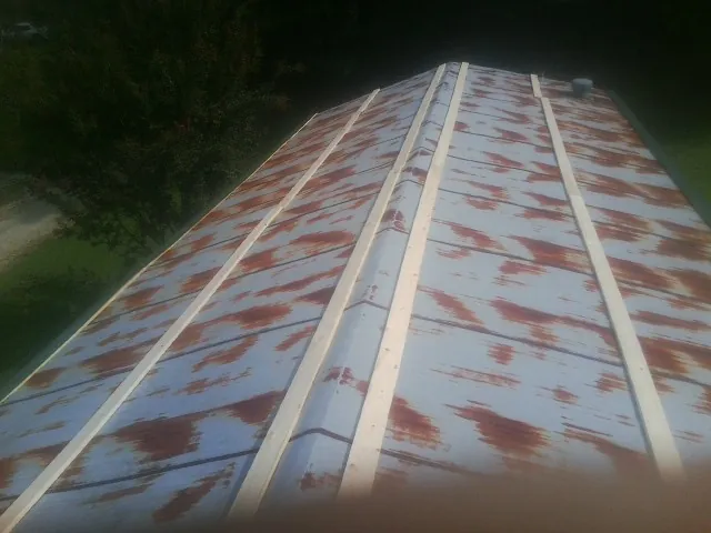 Rusted metal roof panels with new wood purlins before replacement — Storm Damage Roof Repair in Old Saybrook by Roofing Brothers