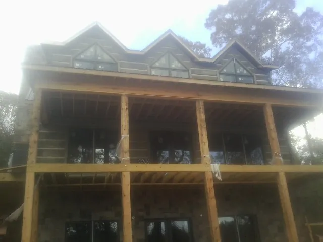 Dormers and porch framing on a large log home under construction — Roof Coating work by our crew in Old Saybrook