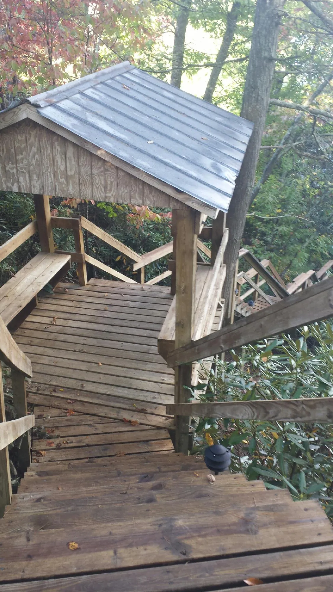 Metal roofed shelter over wooden steps on a wooded walkway — Skylight Repair & Installation work by our crew in Old Saybrook