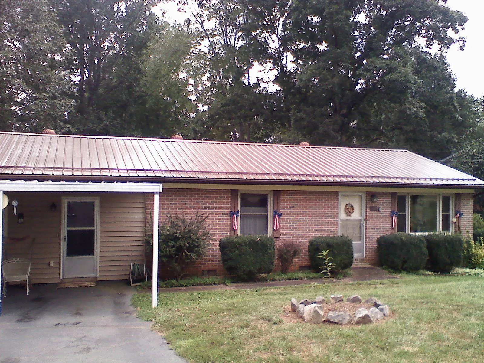 Bronze metal roof and carport on a brick ranch home — Roof Repair work by our crew in Old Saybrook